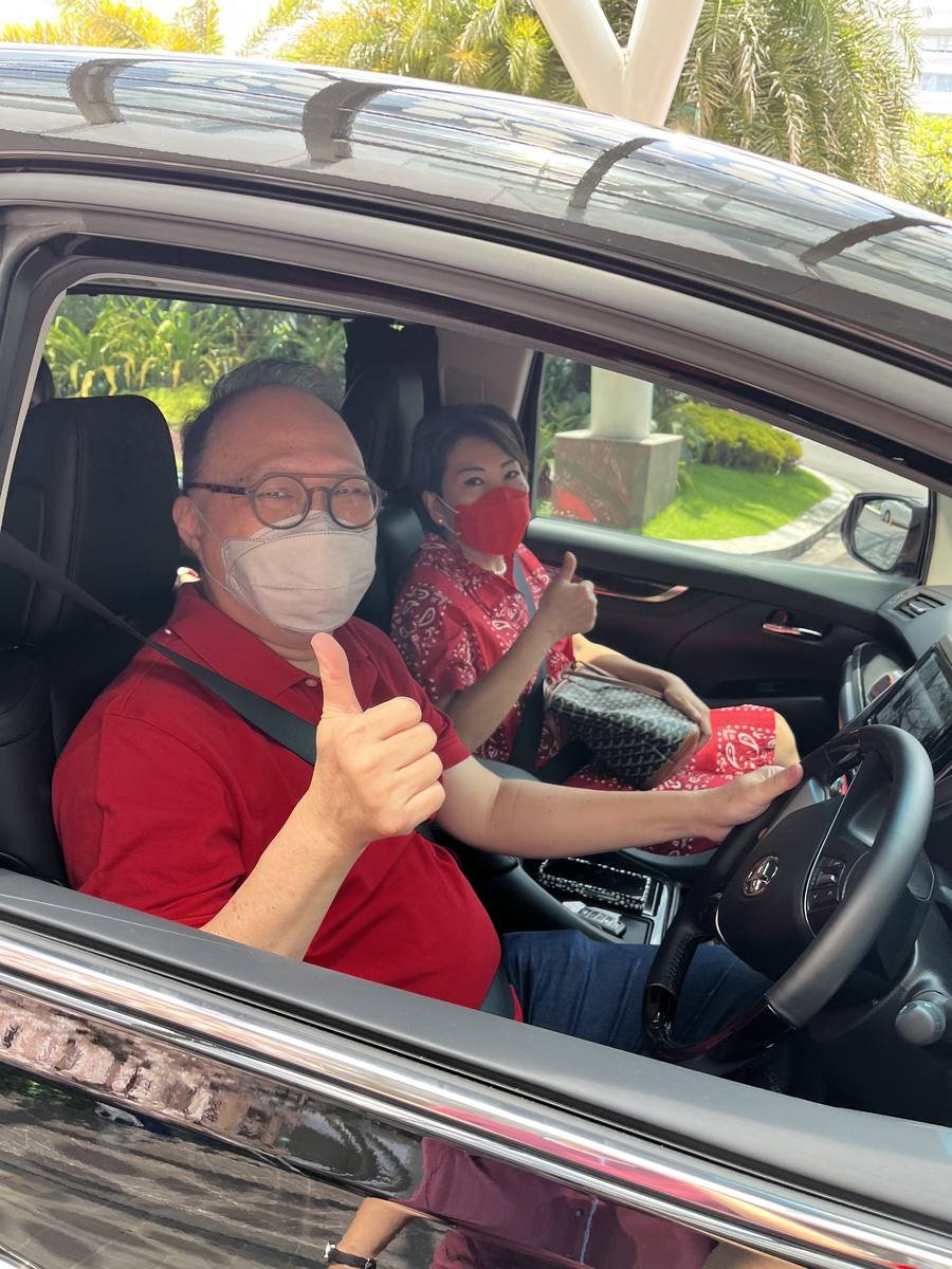 Dua orang di dalam mobil mengacungkan jempol